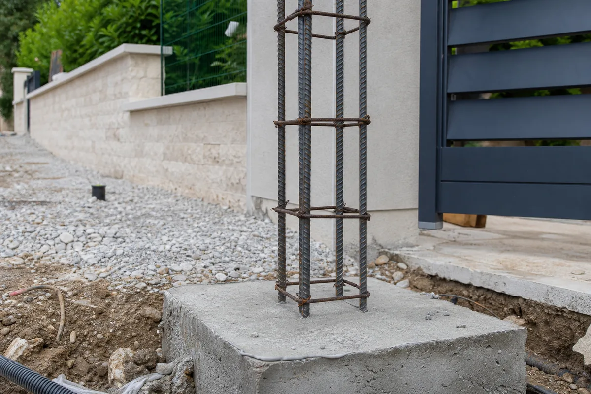 Ferraillage vertical d&rsquo;un pilier de portail en attente sur sa semelle, avant coulage du béton